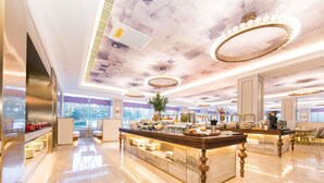 A spacious hotel lobby with a central island, large windows, and a modern ceiling design. - Mercure Turpan Downtown (Turpan)