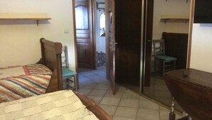 Une chambre à coucher avec un lit, une chaise, un bureau et une armoire.