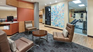 A lobby with a reception desk, seating area, and a large wall map. - TownePlace Suites by Marriott Atlanta Lawrenceville (Lawrenceville)