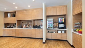 A modern kitchen with wooden cabinets, a coffee machine, and a fruit bowl. - TownePlace Suites by Marriott Atlanta Lawrenceville (Lawrenceville)