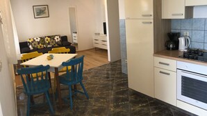 Cocina compacta con comedor, que incluye cafetera, hervidor y estufa.
