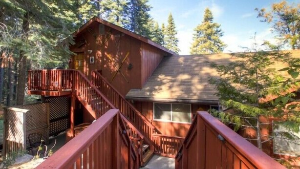 A cabin with a wooden exterior, a staircase leading to a deck, and surrounded by trees. - Scenic Wonders Alpine View 2 Bedroom (Yosemite National Park)