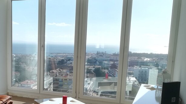 A room with large windows offering a city view.