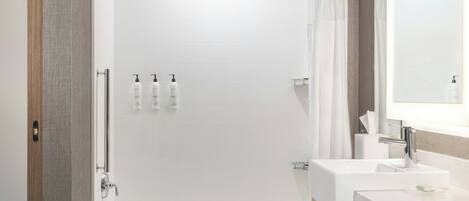 A modern bathroom with a walk-in shower, a bathtub, and a vanity with a sink.