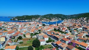 A coastal town with tightly packed buildings, a marina, and a prominent church tower. - Apartments Sunshine Home - Twin Room (Blue) (Vela Luka)
