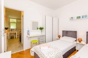 A modern bedroom with a bed, bedside tables, a mirror, a small desk, and a chair. - Apartment Petrana - Studio Apartment with Terrace (Dubrovnik)