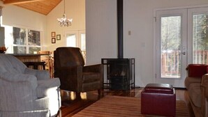 A living room with a fireplace, wooden flooring, and a chandelier. - Scenic Wonders Birds Eye Vista 3 Bedroom (Yosemite National Park)