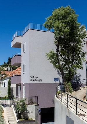 Ein Gebäude namens „Villa Karmen“ mit einer Treppe, die zu einem Eingang führt.