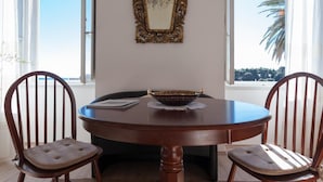 Una mesa de comedor con dos sillas, un cuenco decorativo y un espejo en la pared.