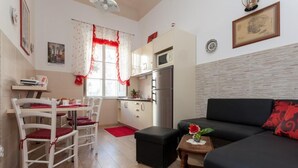Un espacio habitable compacto con kitchenette, comedor y zona de estar.