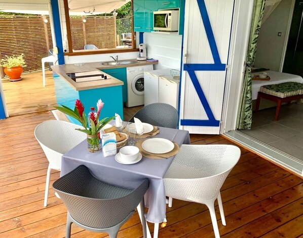 A compact kitchen with a washing machine, a microwave, and a sink.
