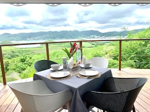 A table set for two with a view of a mountainous landscape. - Creve Coeur Bungalow (Sainte-Anne)