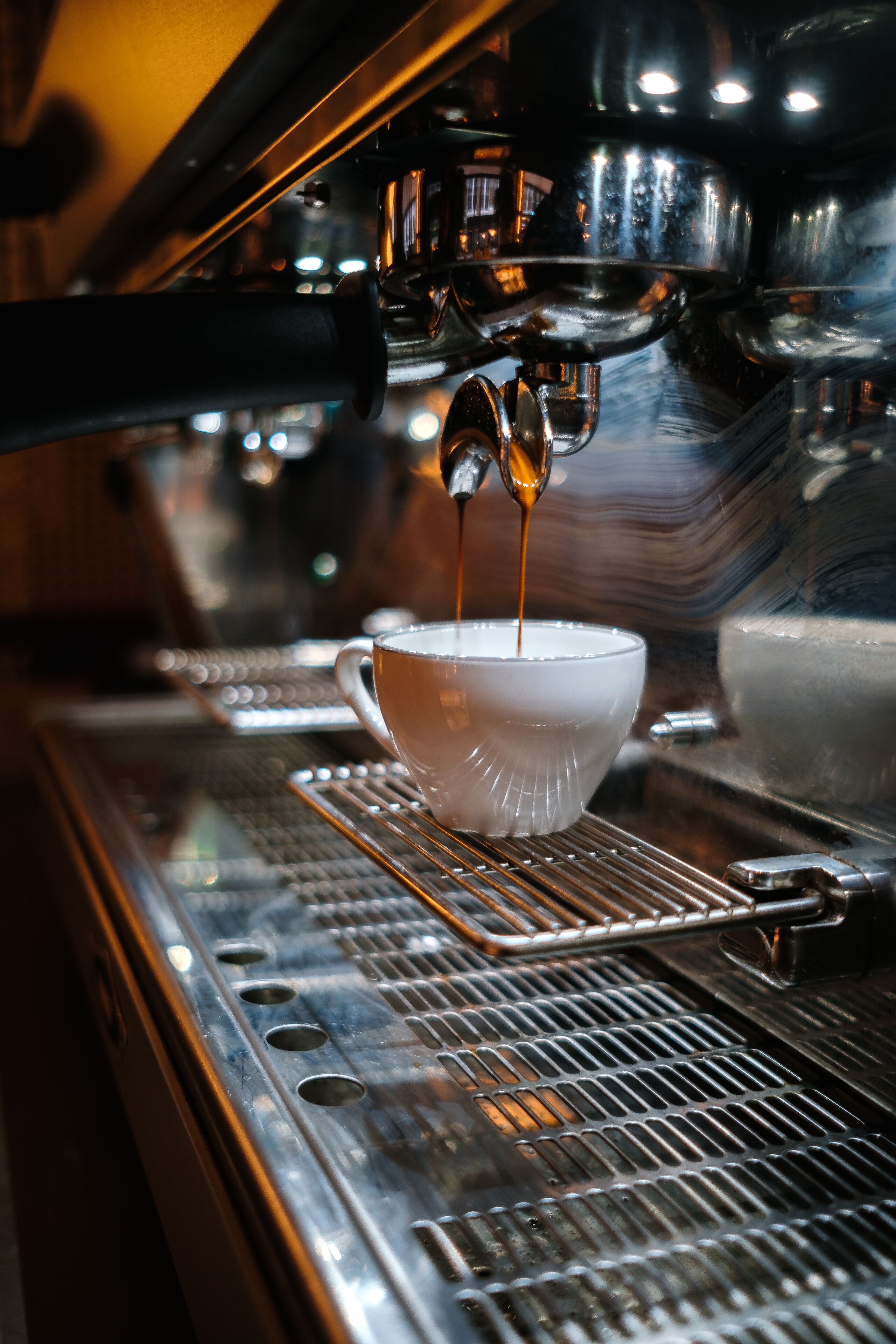 En närbild på en kaffemaskin som häller espresso i en kopp.
