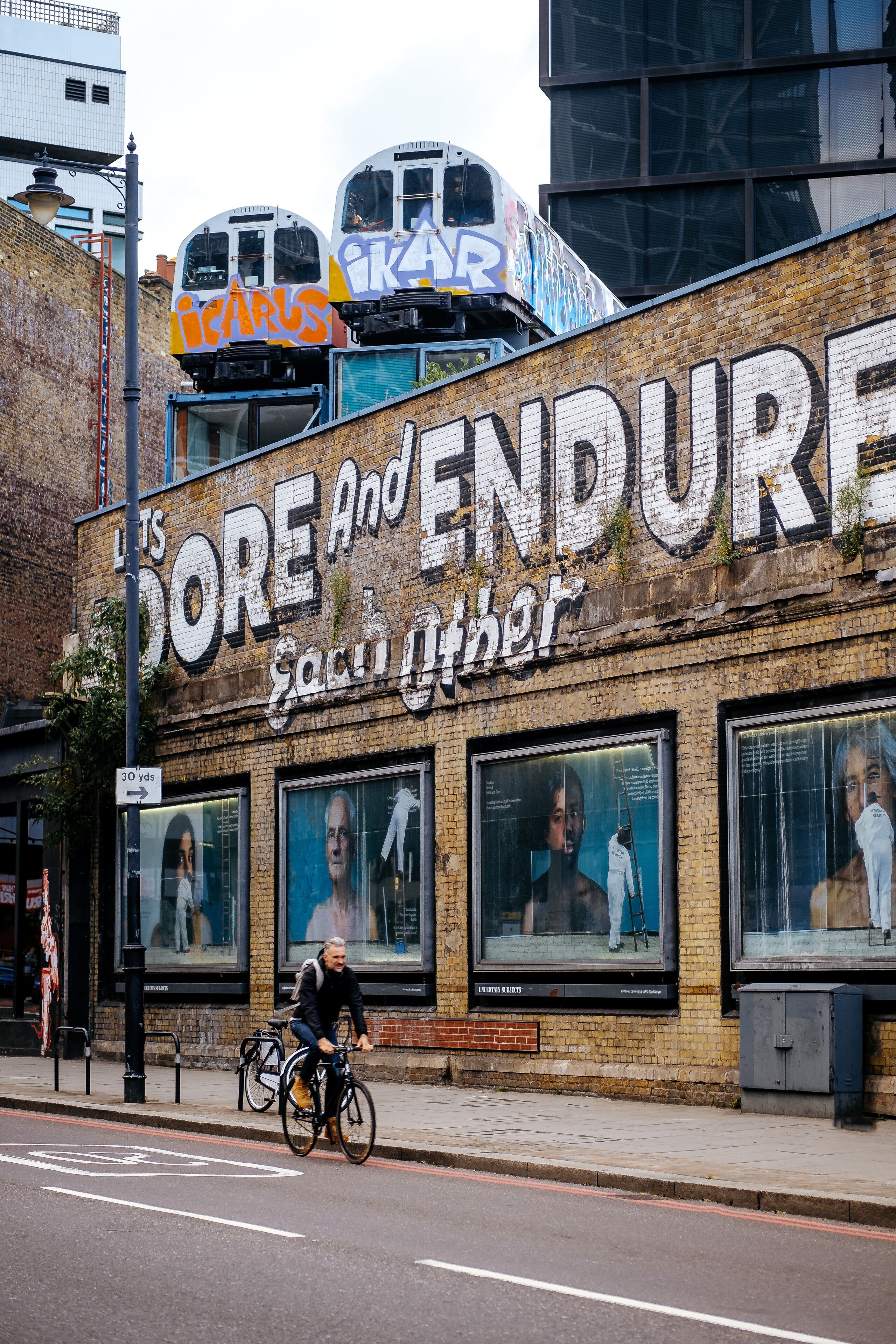 Un edificio con un cartel grande que dice "It's Dore and Endure" y "Sacrifices Other".