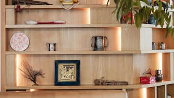 Una estantería de madera con diversos objetos decorativos y un sofá con cojines.