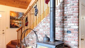 A staircase with a brick wall, a wooden railing, and a black pipe running vertically. - Scenic Wonders Christmas Cabin 3 Bedroom (Yosemite National Park)