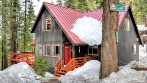 A cabin with a red roof, wooden exterior, and a porch with a red railing. - Scenic Wonders Christmas Cabin 3 Bedroom (Yosemite National Park)