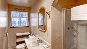 A bathroom with a sink, mirror, and window. - Scenic Wonders Clark Cabin 3 Bedrooms (Yosemite National Park)