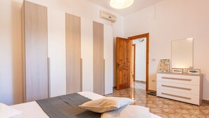 Une chambre à coucher avec un lit, une commode et une armoire.