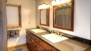 A bathroom with two sinks, wooden cabinets, and a mirror with lights. - Scenic Wonders Dogwood Manor 3 Bedrooms (Yosemite National Park)