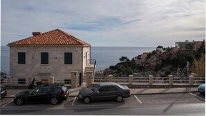 Un bâtiment doté d’un toit recouvert de tuiles, d’un escalier et offrant une vue sur la mer.