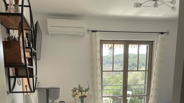 Ein gemütlicher Wohnraum mit Küchenzeile, Essbereich und einem Balkon mit Aussicht.