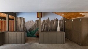 Une pièce décorée d’une fresque représentant une montagne, avec des meubles en bois et un plafond également en bois.