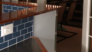 A kitchen with a wooden countertop, a tiled backsplash, and a door leading to a balcony with string lights. - Papa's Place - A secluded lake front property on the edge of Whitefish (Whitefish)