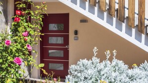 Una puerta roja con un buzón y una pequeña placa en la pared.