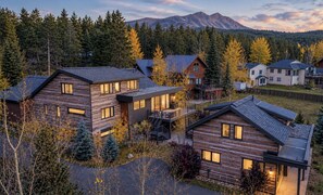 A residential area with modern houses, a mountain in the background, and a forested landscape. - Stunning downtown 8 bed 6.5 bath, hot tub, pool table, steam room, gas fire pit (Breckenridge)