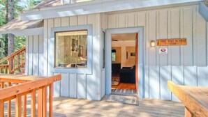 A wooden cabin with a porch, a sign reading "Pine Tree Retreat," and a door leading inside. - Scenic Wonder Pinetree Retreat 3 Bedroom (Yosemite National Park)