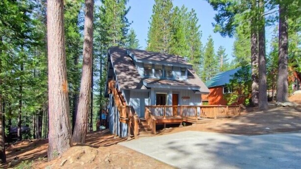 A cabin with a wooden deck, surrounded by tall pine trees. - Scenic Wonder Pinetree Retreat 3 Bedroom (Yosemite National Park)