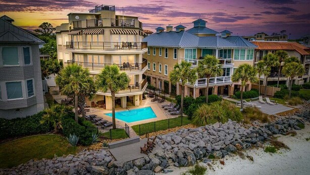 A beachfront property with a swimming pool, multiple balconies, and a view of the ocean. - First Floor, Oceanfront Condo, Concierge Service! (Saint Simons Island)