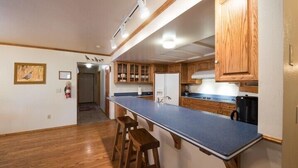A kitchen with wooden cabinets, a blue countertop, and a refrigerator. - Scenic Wonders Quail Crossing 3 Bedrooms (Yosemite National Park)