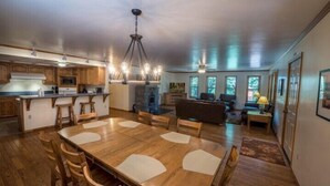 A spacious living area with a wooden dining table, a fireplace, and a cozy seating arrangement. - Scenic Wonders Quail Crossing 3 Bedrooms (Yosemite National Park)