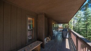A wooden deck with a bench and chairs, overlooking a forested area. - Scenic Wonders Quail Crossing 3 Bedrooms (Yosemite National Park)
