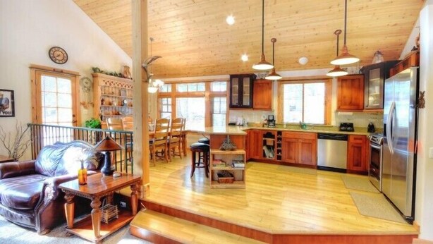 Una cocina amplia con armarios de madera, una isla central y un refrigerador.
