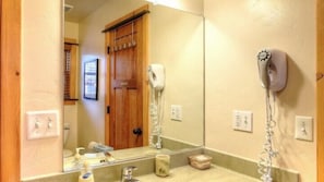 A bathroom with a sink, mirror, and hairdryer. - Scenic Wonder Creek Cabin 3 Bedroom loft (Yosemite National Park)