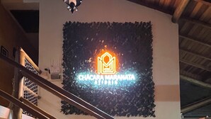 A staircase with wooden railings leading to a room with a neon sign reading "Chácara Maranata." - CHÁCARA MARANATA - ATIBAIA | Rentals for Weekends, Holidays and Seasons. (ATIBAIA)