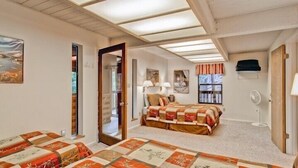 A bedroom with a large bed, a smaller bed, a desk, and a chair. There is a window with curtains and a ceiling fan. - Scenic Wonders Yosemite Escape 3 Bedroom (Yosemite National Park)