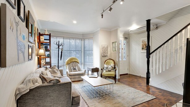 A spacious living room with a sofa, armchairs, a coffee table, and a staircase. - Lauren's Place - This property is the perfect base for exploring all the region has to offer! (BRIGHT)
