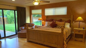A bedroom with a wooden bed, a chair, a nightstand, and a ceiling fan. - Fabulous Red Rock Views, Private Outdoor Space, Hot Tub and Large Fenced Yard. (Sedona)