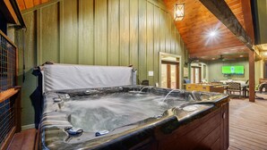 Un bain à remous dans une pièce aux murs en bois et dotée d’un ventilateur de plafond.