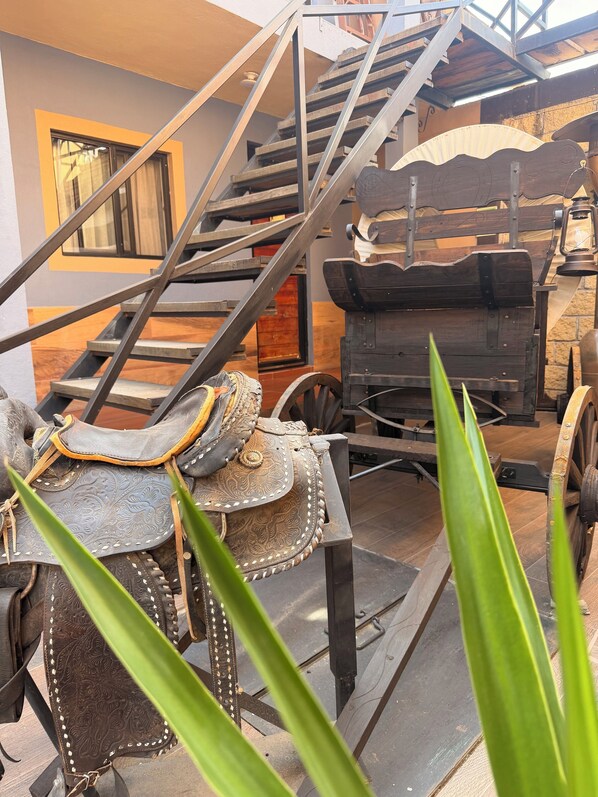 A staircase with metal railings, a wooden bench, and a lantern. - Hotel West Refugio (San Juan del Río)