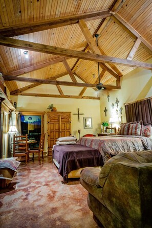 Relax in this inviting room with a large bed, sofa, and dining area.