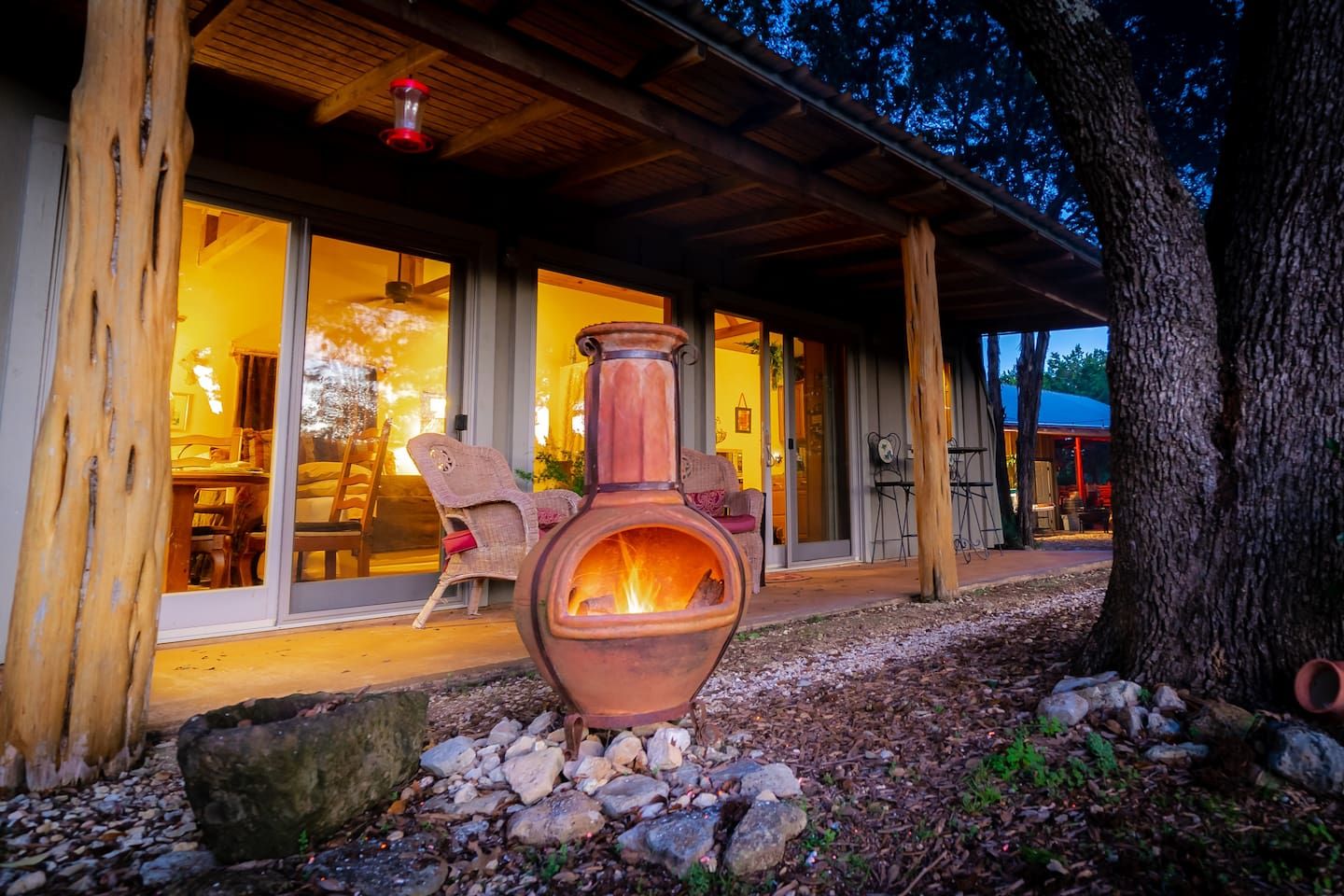 A rustic cabin with a large fireplace, wooden exterior, and a covered porch.