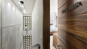 A modern hotel interior with a wooden reception desk, a glass partition with a geometric pattern, and a hanging light fixture. - 2BDR 2.5Bath Vacation House w/Private Pool Steps from the Beach (San Francisco)