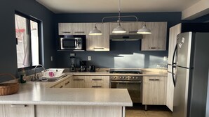 A modern kitchen with a central island, stainless steel appliances, and light wood cabinetry. - Beautiful Private house with huge GARDEN (QUERETARO)