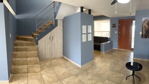 A modern interior with a staircase, a seating area, and a door leading outside. - Beautiful Private house with huge GARDEN (QUERETARO)