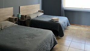 A hotel room with two beds, a ceiling fan, a bedside table with a lamp, and a window with curtains. - Beautiful Private house with huge GARDEN (QUERETARO)